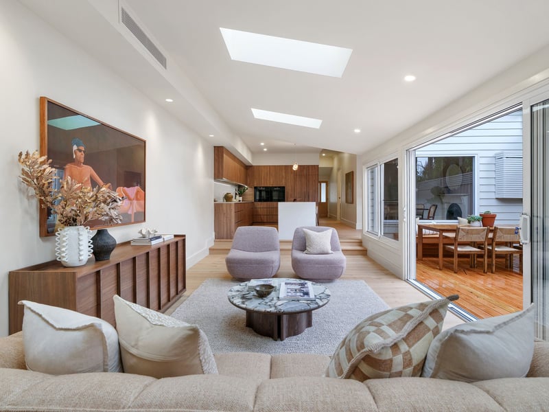 Open-plan living room flowing through to the kitchen and garden deck