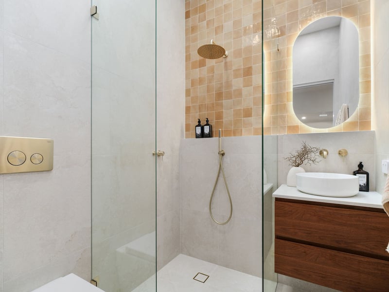 Bathroom with handmade clay-toned tiles, backlit mirror and timber vanity