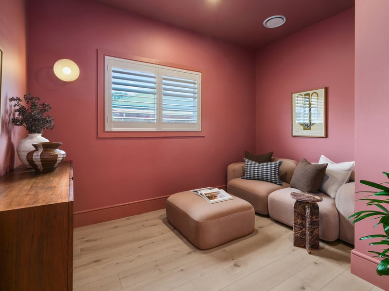 Rose-pink snug with a modular sofa, ottoman, marble side table and timber sideboard